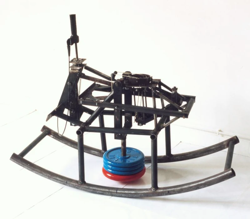 Une mécanique en forme de cheval à bascule produit un mouvement de va-et-vient contrôlé par cames à partir d'un balancier en fonte.