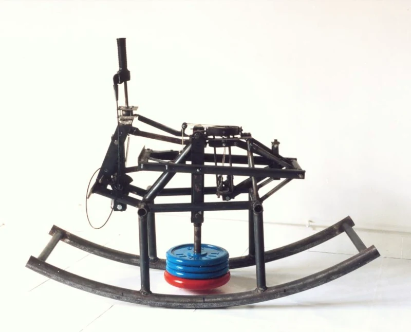 Une mécanique en forme de cheval à bascule produit un mouvement de va-et-vient contrôlé par cames à partir d'un balancier en fonte.